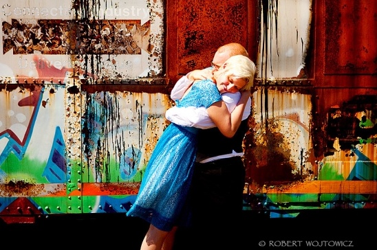Couple embracing in front of a colorful, graffiti-covered wall
