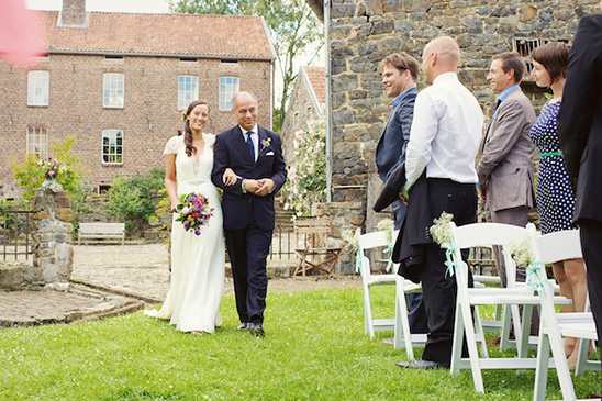 Bride walking down the aisle with her father at outdoor wedding