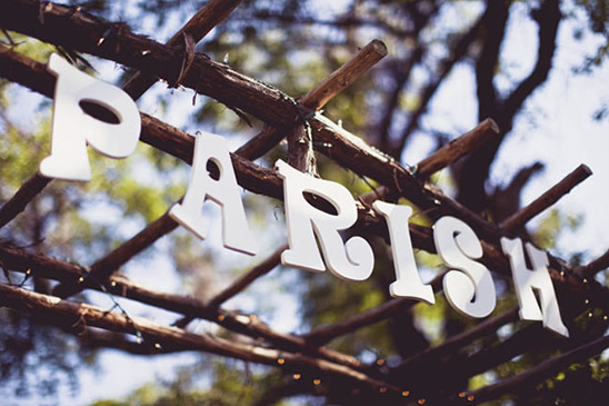 Parish sign made of white letters on rustic wooden branches outdoors