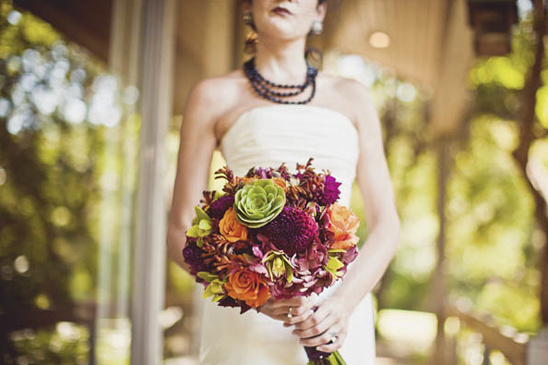 Bride holding vibrant bouquet of wedding flowers, close up shot