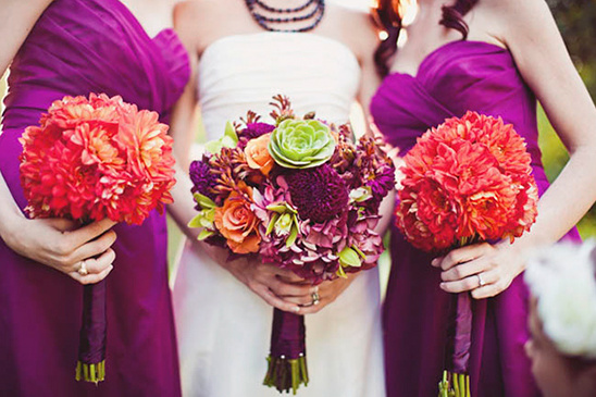 Bridesmaids holding vibrant bouquets at a colorful wedding