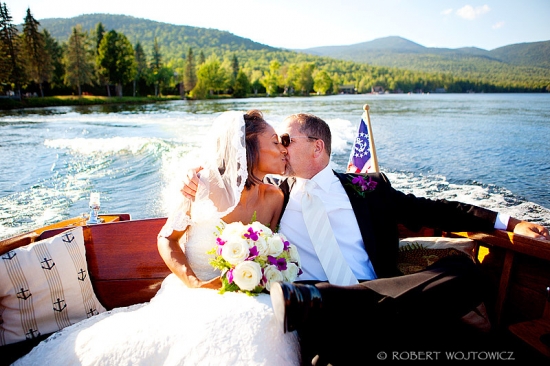 Bride and groom kissing on a boat during a beautiful wedding day