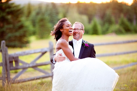 Happy bride and groom laughing on their wedding day, lifted