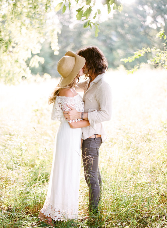 Romantic couple kissing outdoors with sunlight filtering through
