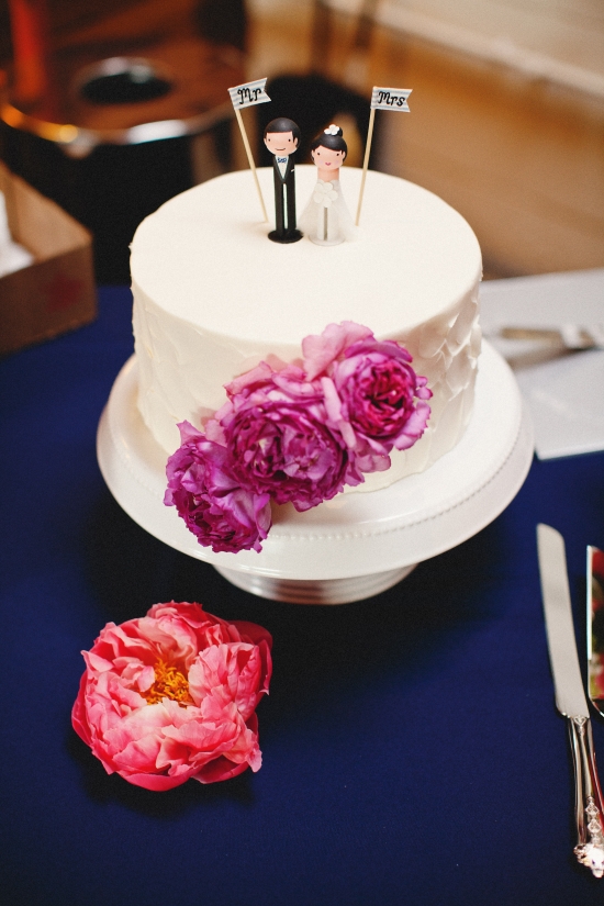 Wedding cake with Mr and Mrs toppers and purple roses on the blue cloth