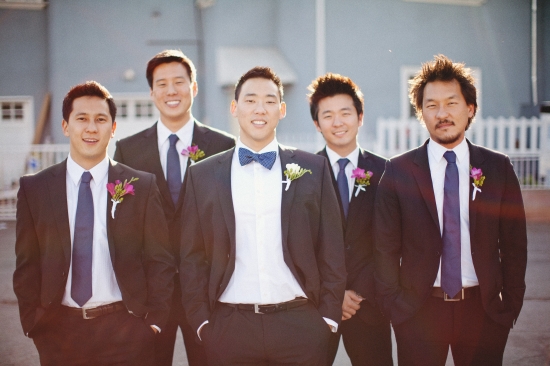 Groomsmen in suits smiling at wedding, perfect for a group photo