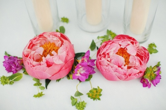 Two pink peonies with fresh flowers and a stylish glass background