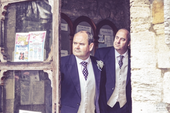 Two men in suits stand in a doorway, ready for the wedding