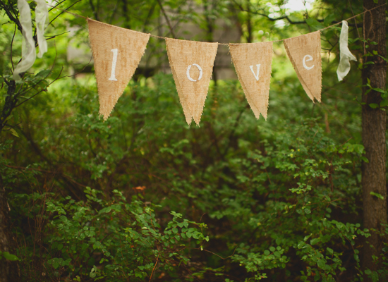 Rustic banner with love message hanging in lush green forest