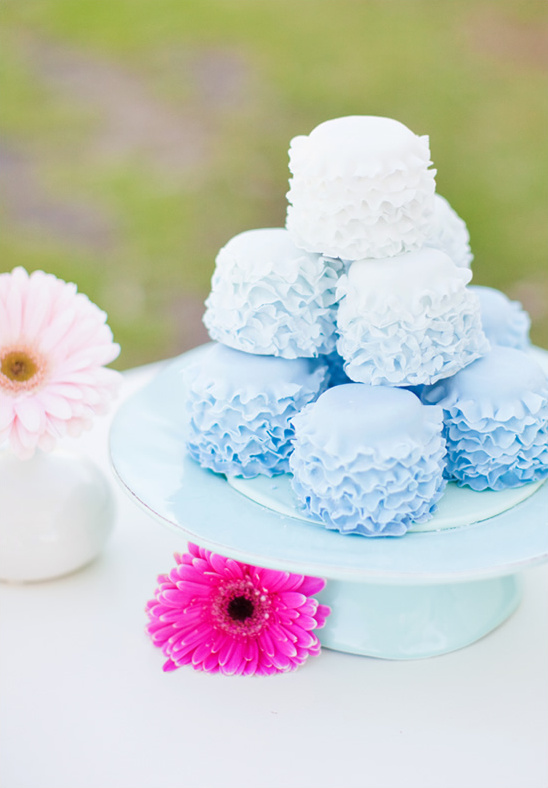 Elegant blue and white mini cakes with flowers on a pastel cake stand
