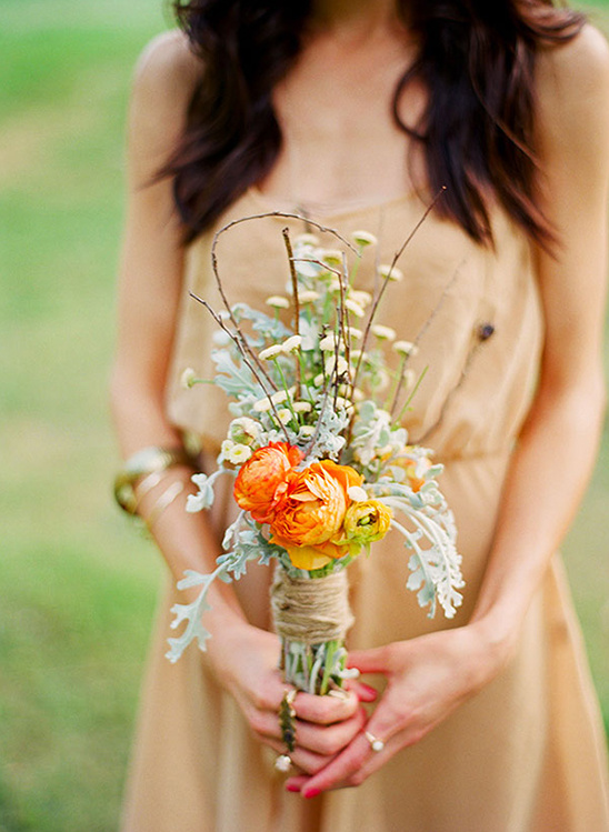 Woman holding a bouquet of bright orange and yellow flowers