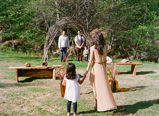 A mother and daughter walking towards a ceremony in the green nature