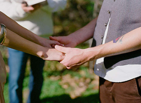 Couple holding hands during wedding ceremony, vows and commitment