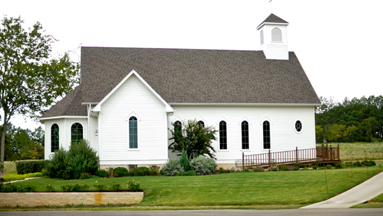 White country church with a bell tower in the landscape