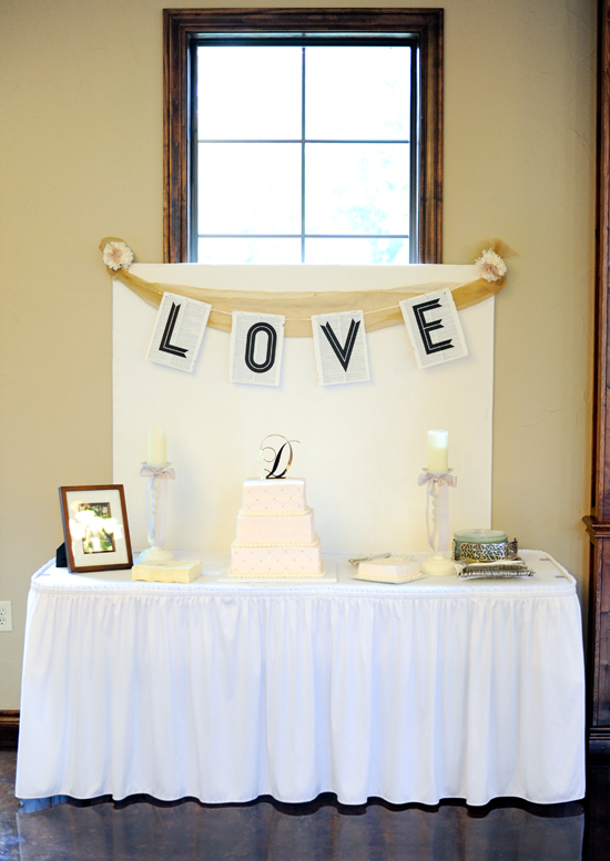 Elegant wedding reception decor with a tiered cake and LOVE banner