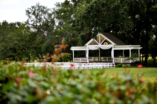 Outdoor wedding ceremony setup with gazebo and rows of chairs