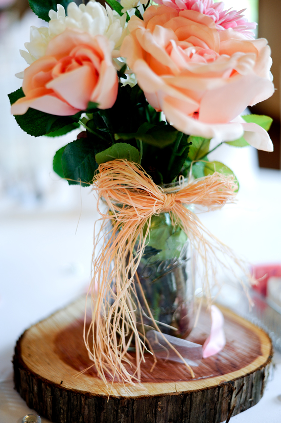 Bouquet of roses in a mason jar on a wooden slice centerpiece