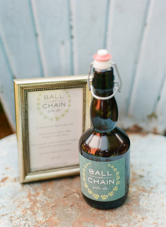 Ball and Chain Pale Ale bottle with framed sign on rustic table