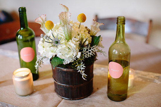 Elegant flower arrangement with candles and green glass bottles