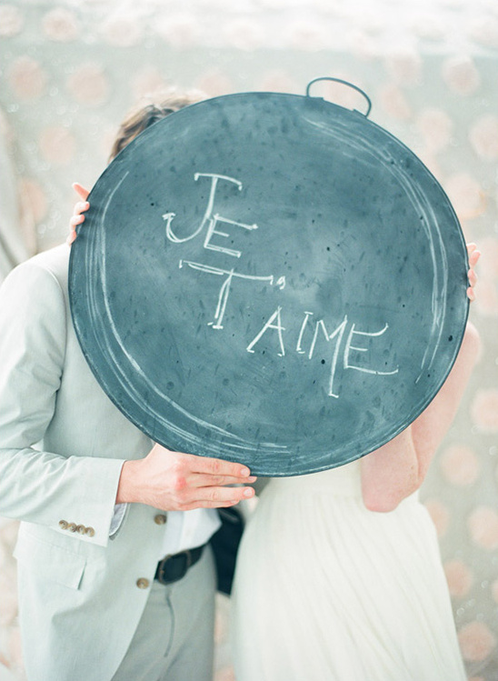 Couple holding a sign that says Je T'aime at their wedding