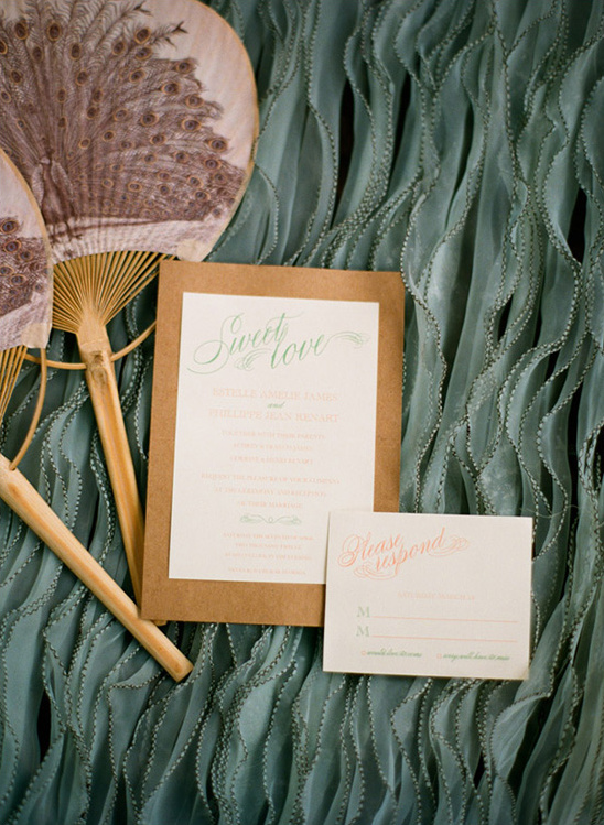 Wedding invitations with peacock fans and blue fabric