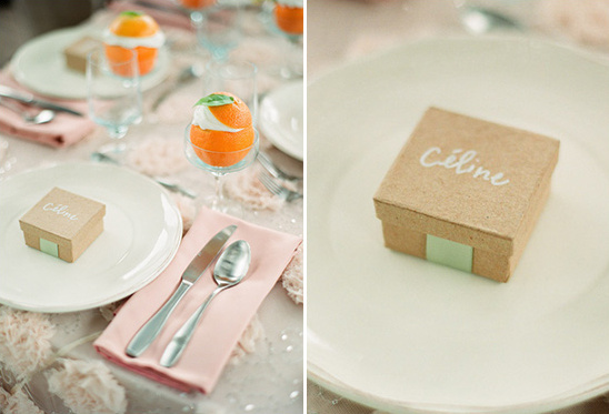 Elegant table setting with orange fruit and personalized favor boxes