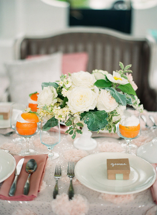 Elegant wedding table setting with flower centerpiece and oranges