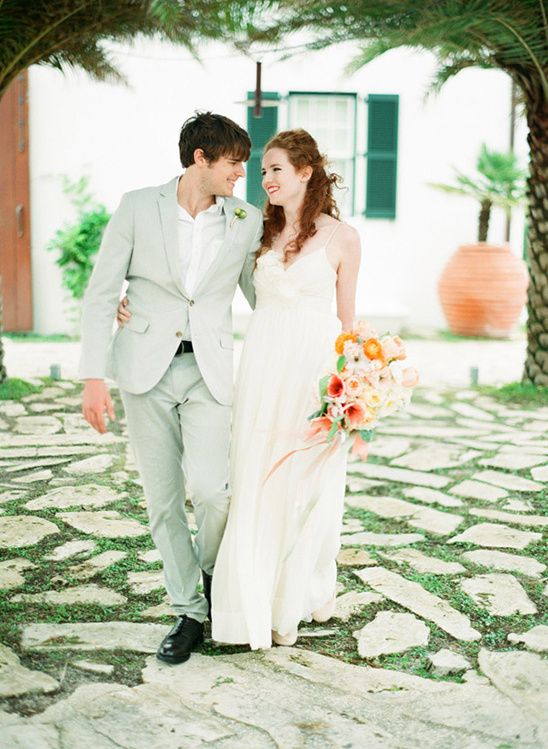 Happy couple walking on a stone path at their wedding