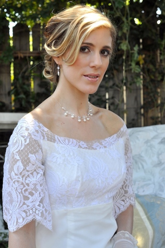 Beautiful bride wearing a white lace wedding dress and pearls