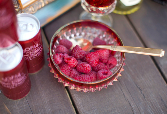 Sofia wine cans and fresh raspberries in a glass bowl