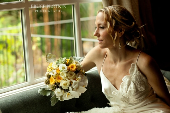 Bride with yellow and white bouquet by window