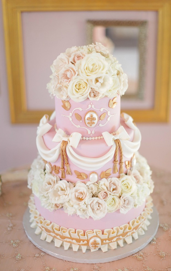 Elegant pink wedding cake with white roses and gold accents