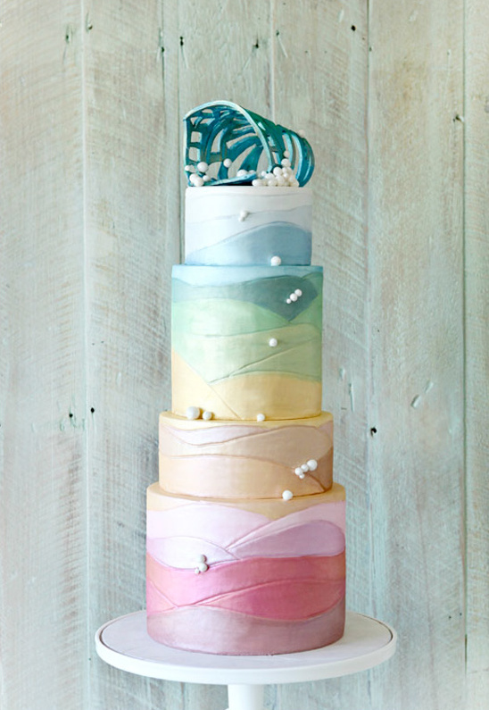 Multi-tiered pastel wedding cake with leaf topper