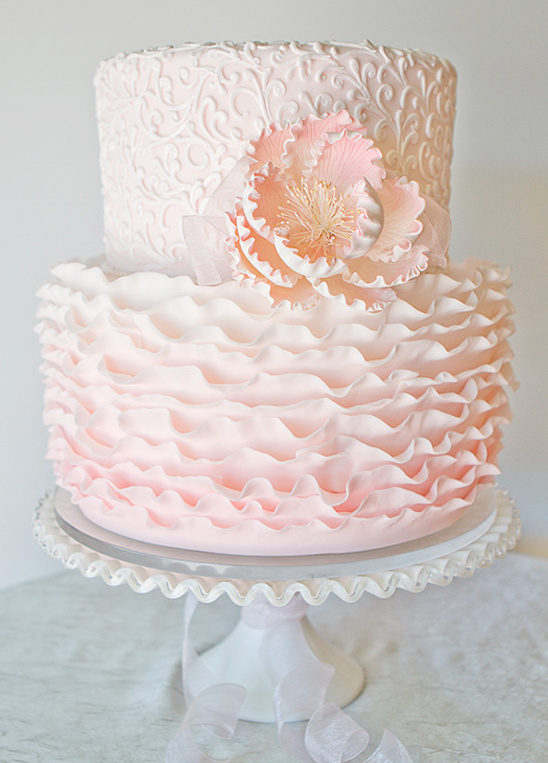 Elegant pink ruffled two tier wedding cake with flower