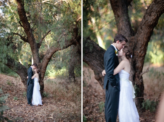 Bride and groom embrace under a rustic tree