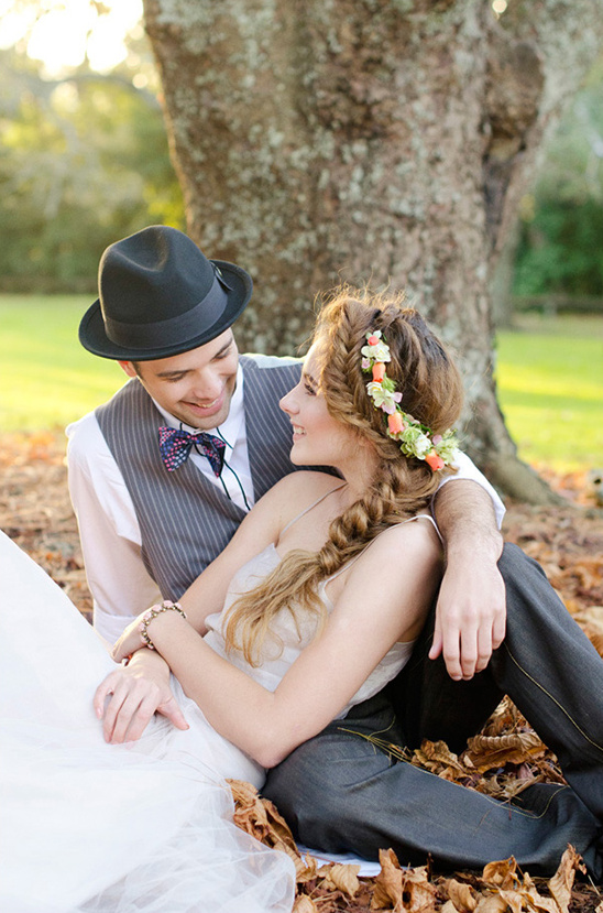 Stylish bride and groom pose under a tree on their wedding day