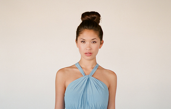 Woman with topknot hairstyle wearing a light blue halter dress