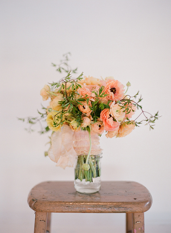 Peach and yellow ranunculus bouquet in a jar