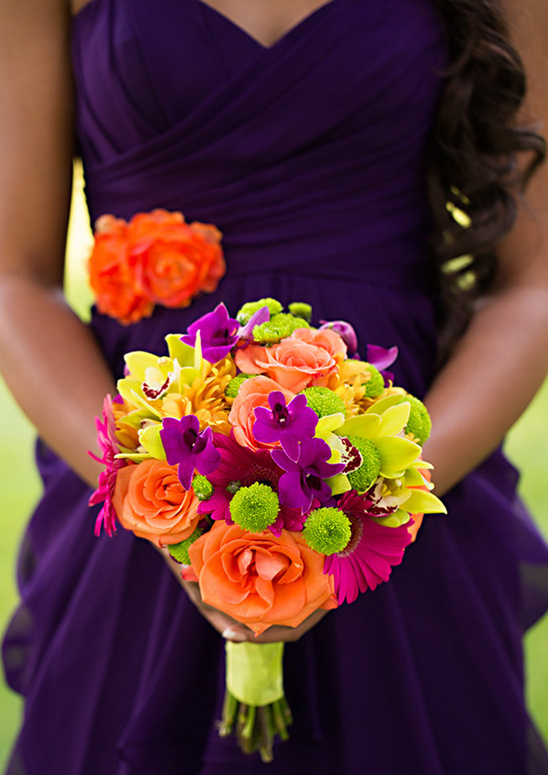 Bridesmaid in purple dress holding bright flower bouquet
