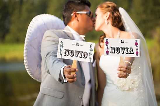Bride and groom holding El Novio and La Novia signs