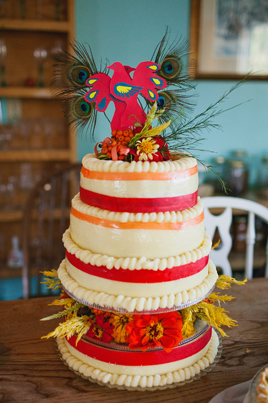 Three-tiered wedding cake decorated with peacock and flowers