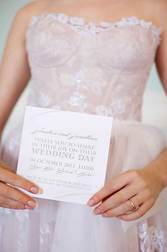 Bride in wedding dress holding invitation card