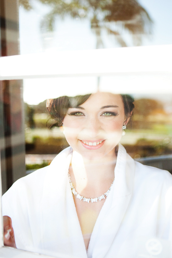 Bride gazes through window on her wedding day
