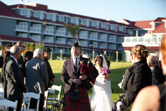 Bagpiper leads the wedding procession on grassy lawn