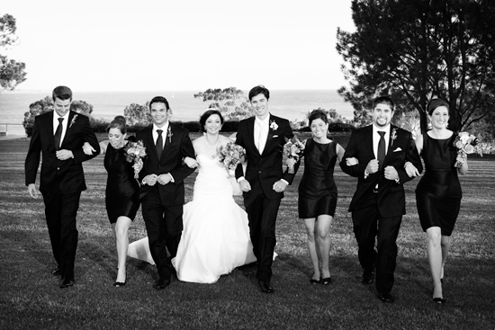 Black and white wedding party photo on green lawn