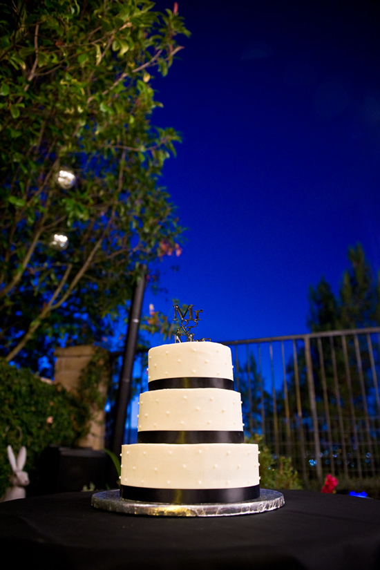 Elegant white wedding cake with black ribbon accents