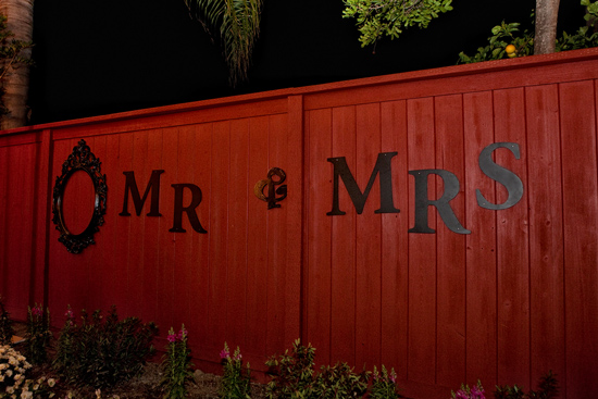 Red fence displays Mr & Mrs in large metal letters