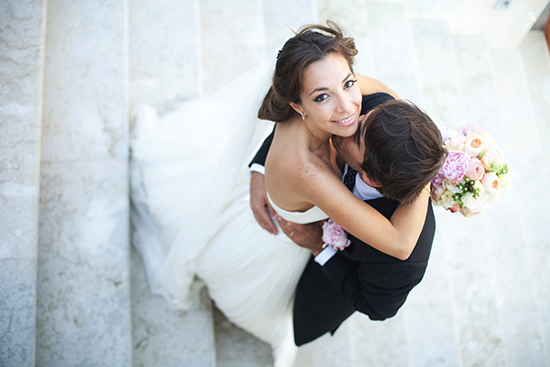 Happy bride and groom embracing on stairs