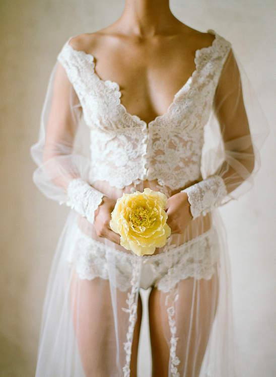 Woman in lace lingerie holding a yellow peony
