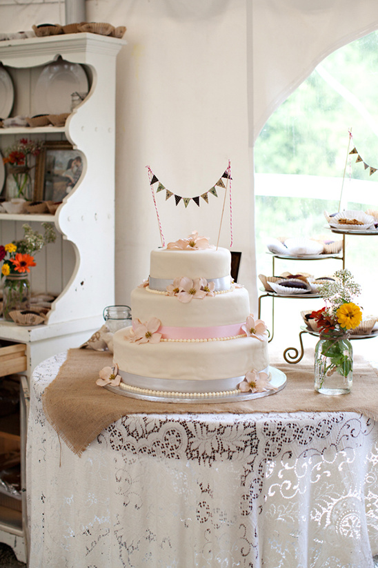 Three-tiered wedding cake with pink flowers